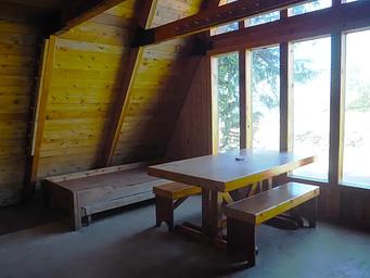 Inside of Steamer Bay cabin with table, benches, and bunks.
