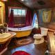 Interior bathroom with freestanding tub, stained-glass window and rustic finishes — highlights unique bathroom facilities inside a treehouse (homepage/treehouses imagery).