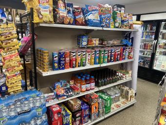 A convenience store shelf stocked with snacks and drinks at Trailin RV Park.