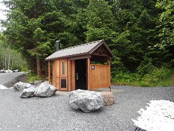 outhouse with large boulders and trees