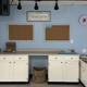 Organized classroom corner with white cabinets, bulletin boards, and a welcome sign.