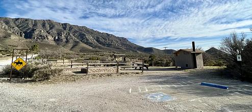 Frijole Horse Corral Campsite with RV parking spaces in the foreground, tent pads, picnic table and restroom are shown.
