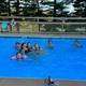 Outdoor heated swimming pool with guests — shows on-site pool amenity and surrounding fence/trees (image from resort site).
