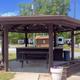 Covered picnic/gazebo structure with picnic tables and RV hookups visible behind it — useful to illustrate common-area seating and nearby RV sites (source: site homepage).