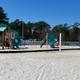 Playground area set in sand with play structures visible — useful for showing on-site family amenities and beach-front recreation (from the property gallery).