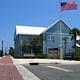 two story blue building along the waterfront with American flag flying