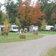 Wide shot showing multiple RV sites, playground equipment and campground road — useful for illustrating site spacing and amenities (gallery image).
