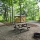 Picnic area and gazebo in a wooded campsite setting, showing campsite furniture, gazebo and surrounding trees — from the property’s Gallery page.