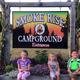 Children sitting in front of Smokerise Campground sign at entrance to park.