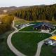 Aerial/drone view showing the barn/event building, surrounding drive, outdoor seating area and layout of the grounds — useful overview of the property (source: main site imagery).