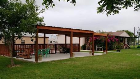 The covered clubhouse pavilion with tables and bougainvillea