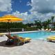 Pool that has sun shelf with chairs