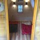 Interior view of a camp pod (small cabin) showing sleeping area and finishes — documents on-site lodging option (from the gallery).
