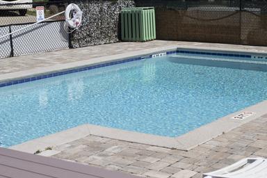 Clear photograph of the resort pool and paved patio area — labeled on the site’s North Amenities page and used to illustrate on-site recreational facilities.