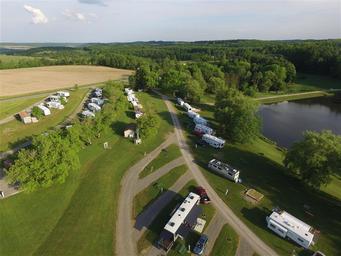 High-angle/drone view of RV sites, roadways and the pond giving a clear look at pitch layouts and terrain — labelled on the Overview page.