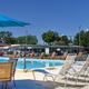 Resort heated swimming pool surrounded by deck chairs and umbrellas at Rice Creek RV Resort ground.