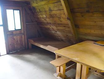 Mount Flemer Cabin interior showing wood table and bed