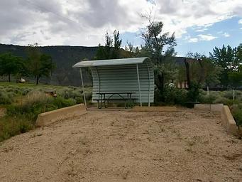 Picnic table with a shelter covering one side and over head and parking in the front.