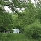 Cleary shows campground amenities: RV, cabin and large shade trees — useful to illustrate lodging/pitch variety and site layout.