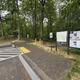 Handicapped parking and a paved walkway beside information signs in a forest