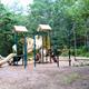 Playground equipment in a wooded setting — shows family-friendly recreation facilities located on the campground property (displayed in the site's images).