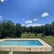 Elevated view showing the pool, fenced recreation area and playground with campground grounds and RVs in the distance — good overall layout/overview shot (from the property photo gallery page).