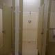 A unit bathhouse interior, showing showers and toilet.