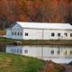 Barn or outbuilding reflected in the pond — provides a distinct architectural feature and broader view of the property grounds (included on the venue site).