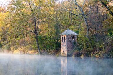 an old brick tower on the edge of a river