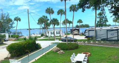 Elevated view of RV sites, grassy area and waterfront with docks — useful overview showing RV pitches and layout near the water (site homepage/gallery).
