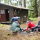 People building a fire with Harding River Cabin in background