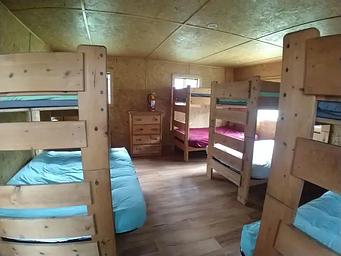 large bedroom with 4 bunk beds and a dresser