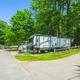 Well-composed image of a full-hookup RV site and paved roads through wooded sites — useful to show the campground's RV accommodations (from the 'RV site rentals' page).