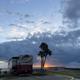 Sunset scene showing an RV parked near the sea wall and a section of the grounds — captures atmosphere, RV parking, and waterfront setting (social/gallery image on the site).