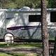 RV parked at a campsite with visible utility hookups and picnic table — useful depiction of RV sites and campsite layout (source: Rates page featured images).