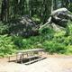 Campsite picnic table set against large natural rock outcrop — useful depiction of individual campsite character and surroundings from the site's photo gallery.