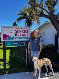 Vertical photo of the park’s main sign with a person and dog at the entrance — useful identifying shot for the property and appears in the park’s About/entrance gallery.