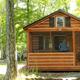 Front view of a park-model cabin on a wooded site — clearly depicts on-site cabin rental accommodation. Image appears on the Park Model Cabin Rental page of the property website.