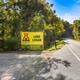 Entrance roadway with prominent 'Lake Logan KOA' sign and surrounding trees — establishes property identity and shows the campground entrance (used as a background/intro image for the campground page).