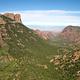 A view of Chisos Basin from the Lost Mine trail. Green vegetation with red mountains