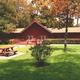 Front view of the clubhouse building with lawn and picnic table in foreground — facility photo shown on the park website (page: https://rainbowsend.escapeesrvparks.com/).