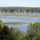 Wide coastal/marsh view across the bay that complements the waterfront shots; hosted on the property site’s Features page (cape-ann-camp-photo2A.jpg) and illustrates nearby water scenery visible from the campground.