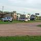 Ground-level photo showing gravel roads, parked RVs and vehicle hookups — illustrates site layout and accessibility (source: Amenities page header image).