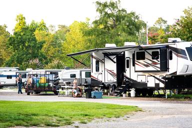 Ground-level view of RV sites and a fifth-wheel setup with site amenities and landscaping — from the community/gallery images on the property site, useful for illustrating typical RV pitches.