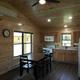 Interior wide shot of the cabin living/dining/kitchen with wood paneling and appliances — demonstrates interior finishes and amenity quality.