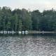 Shoreline with multiple boats moored at docks across the pond — depicts the camp’s boat docks and waterfront facilities (from the ‘Around the Camp’ page).