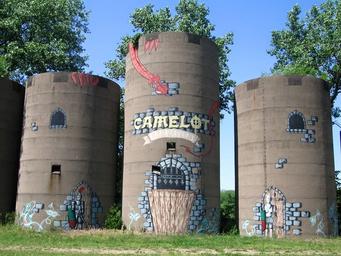 Three painted silo towers with 'Camelot' artwork — distinctive on-site landmark / property feature used on the campground website.