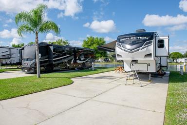 Concrete RV pads with two parked units and palm trees — typical onsite RV pitch view from the gallery showing site setup and spacing.