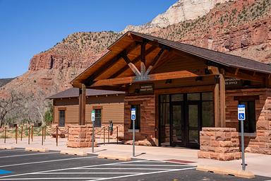 Campground reservation and wilderness permit office at South Campground in Zion National Park, with sandstone cliffs rising behind the building.