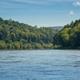 Wide river view with wooded riverbanks — establishes the scenic riverside setting of K-Camp (used on the site's camping pages).